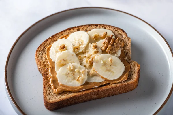 Otevřený Sendvič Plátku Celozrnného Chleba Arašídovým Máslem Banány Drcenými Vlašskými — Stock fotografie