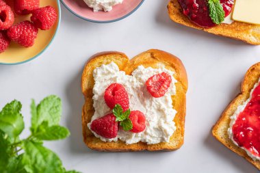 Brioche ekmeği dilimleri, ricotta peyniri, taze ahududu ve naneli sandviç.