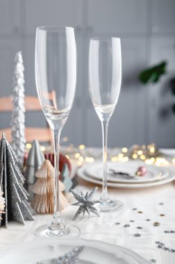 Beyaz ve pembe renkli Xmas masa ayarları arka planda modaya uygun kağıt Noel ağaçları, boş tabaklar ve şenlikli akşam yemeği ve parti için hazır bardaklar