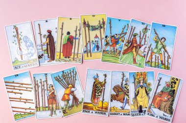 London, UK: 6 January, 2023: Minor Arcana - Suit of Wands of Tarot Card of Rider Waite deck in hand on pink background clipart