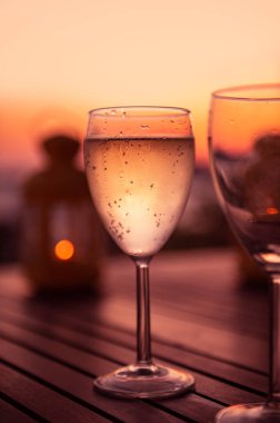 Soğuk ev beyaz şarabı tatil boyunca servis edilir. Arka planda muhteşem bir gün batımı.