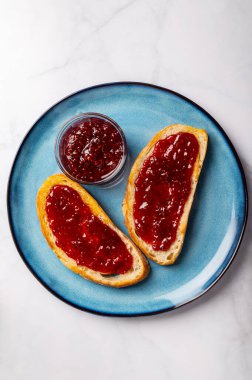 Open Sandwich with toasted sourdough white bread slices and raspberry jam