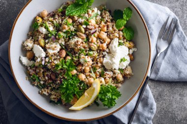 Quinoa, salatalık, otlar, fıstıklar, nohut ve Feta 'dan limon suyu ve zeytinyağıyla yapılmış sağlıklı bir salata. Adı Jennifer Aniston Salatası. Taze, çıtır çıtır ve bitkisel proteinle dolu.