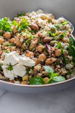Quinoa, salatalık, otlar, fıstıklar, nohut ve Feta 'dan limon suyu ve zeytinyağıyla yapılmış sağlıklı bir salata. Adı Jennifer Aniston Salatası. Taze, çıtır çıtır ve bitkisel proteinle dolu.
