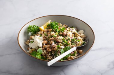 Quinoa, salatalık, otlar, fıstıklar, nohut ve Feta 'dan limon suyu ve zeytinyağıyla yapılmış sağlıklı bir salata. Adı Jennifer Aniston Salatası. Taze, çıtır çıtır ve bitkisel proteinle dolu.