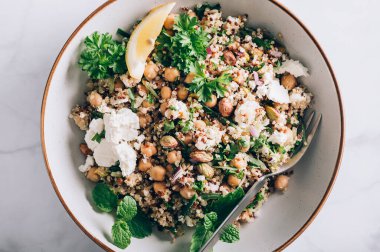 Quinoa, salatalık, otlar, fıstıklar, nohut ve Feta 'dan limon suyu ve zeytinyağıyla yapılmış sağlıklı bir salata. Adı Jennifer Aniston Salatası. Taze, çıtır çıtır ve bitkisel proteinle dolu.