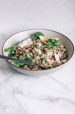 Quinoa, salatalık, otlar, fıstıklar, nohut ve Feta 'dan limon suyu ve zeytinyağıyla yapılmış sağlıklı bir salata. Adı Jennifer Aniston Salatası. Taze, çıtır çıtır ve bitkisel proteinle dolu.