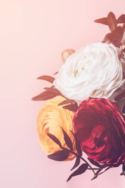Fotokopi alanı olan pembe arkaplandaki vazodaki ranunculus çiçekleri. Çiçek aranjmanında bir demet İranlı düğün çiçeği.