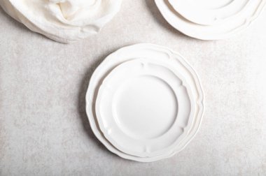 Beyaz seramik tabakta düz bir zemin üzerinde peçete var.