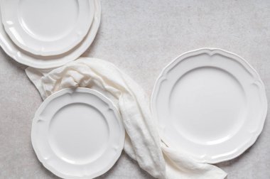 Beyaz seramik tabakta düz bir zemin üzerinde peçete var.