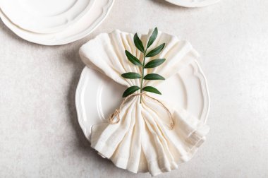 Beyaz seramik tabakta düz bir zemin üzerinde peçete var.