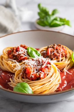 Vejetaryen spagetti bolonez, domates soslu mercimek, parmesan peyniri ve fesleğen yaprağı. Sağlıklı vejetaryen gıda kavramı