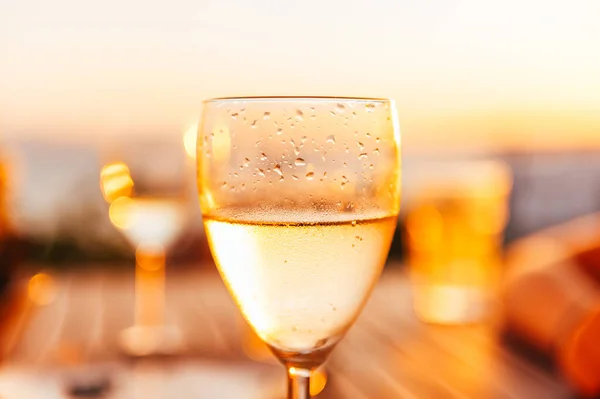 居酒屋で提供される伝統的な家の白ワイン 伝統的なギリシャの飲み物 背景として素晴らしい夕日 — ストック写真