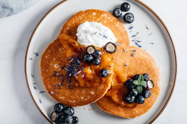 Portakal reçelli taze Amerikan gözlemeleri, yabanmersini ve hindistan cevizli yoğurt, mükemmel kahvaltı.