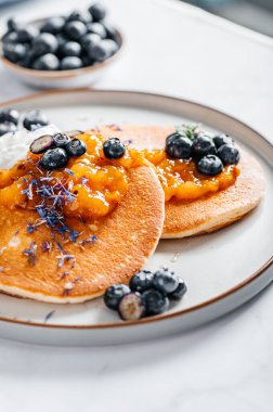 Portakal reçelli taze Amerikan gözlemeleri, yabanmersini ve hindistan cevizli yoğurt, mükemmel kahvaltı.