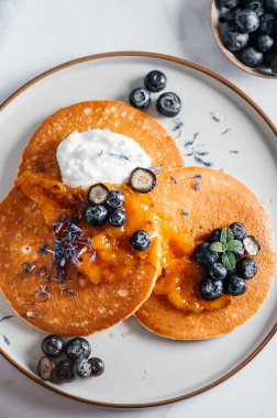 Portakal reçelli taze Amerikan gözlemeleri, yabanmersini ve hindistan cevizli yoğurt, mükemmel kahvaltı.
