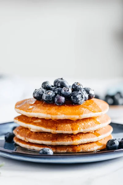 stock image Fresh American Pancakes with blueberries and maple syrup on blue plate