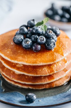 Mavi tabakta yaban mersinli ve akçaağaç şuruplu taze Amerikan gözlemeleri.