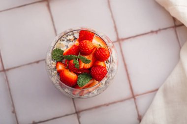 Badem sütü ve böğürtlen suyundan yapılmış taze çilekli bardaktaki sağlıklı chia pudingi. Güne sağlıklı başlamak için mükemmel bir kahvaltı.