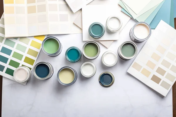 家の改装中に小さなサンプル塗料缶 壁のための塗料を選択するプロセス 異なる緑とベージュの色 背景上のカラーチャート ロイヤリティフリーのストック画像