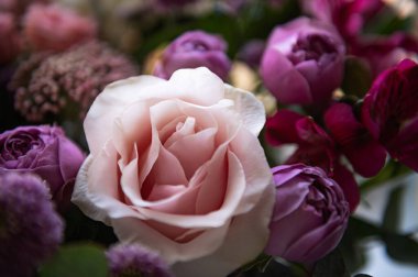 Güzel bir buket gül, çingene çiçeği ve koyu arkaplanda diğer farklı çiçekler.