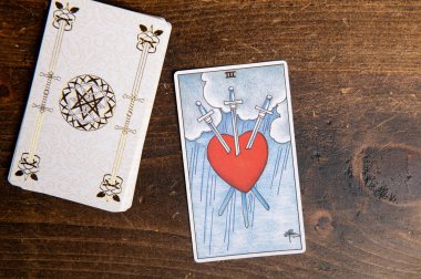 Londra, İngiltere: 4 Ocak 2024: Minor Arcana - Süvari Bekleme Güvertesinin Üç Tarot Kartı ahşap arka planda