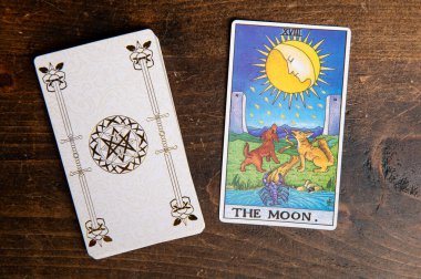 Londra, Birleşik Krallık: 4 Ocak 2024: The 18 Major Arcana - The Moon Tarot Card of Rider Waite deck on wood background