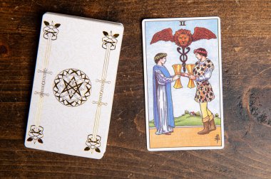 London, UK: 4 January, 2024: Minor Arcana - Two of Cups of Tarot Card of Rider Waite deck on wooden background clipart