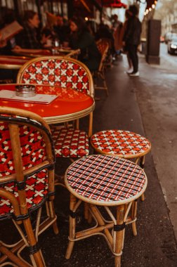Paris, France - March 30, 2024: Parisian street and cafe details. Cute table and chairs. Toned image clipart