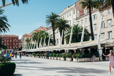 Split, Hırvatistan - 25 Mayıs 2024: Split 'in ana limanı olarak bilinen Riva, bir çok dükkan ve kafesi olan turistler için deniz kenarı gezinti alanı ve popüler bir yerdir.