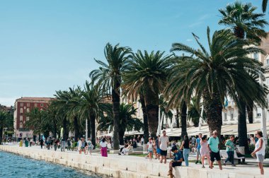 Split, Hırvatistan - 25 Mayıs 2024: Split 'in ana limanı olarak bilinen Riva, bir çok dükkan ve kafesi olan turistler için deniz kenarı gezinti alanı ve popüler bir yerdir.