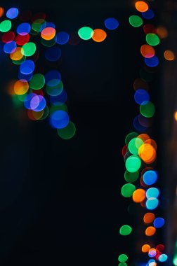 Siyah izole edilmiş arka planda Noel ışıklarından yapılmış renkli soyut bir Bokeh. Tatil konsepti, bulanık bokeh, resimleriniz için örtüşür.