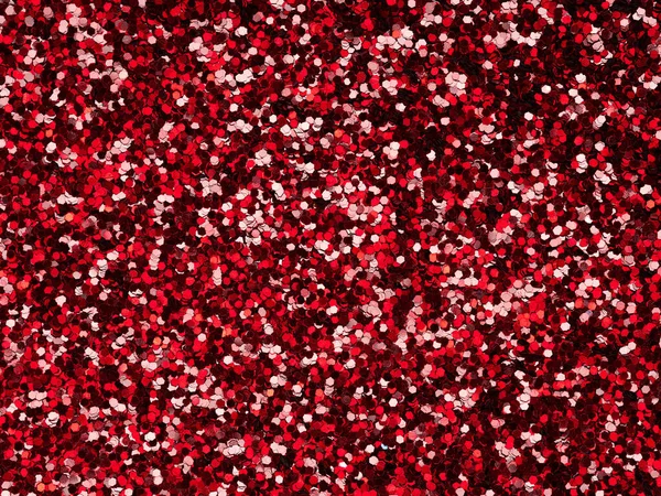 Red glitter. Perfect holographic background or pattern of sparkling shiny glitter for decoration and design of Christmas, Valentine Day, New Year, xmas gift card or other holiday pictures.