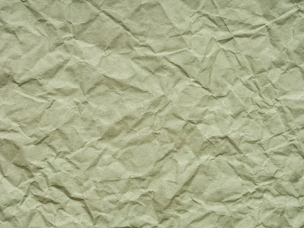 Texture of crumpled green craft paper. Crumpled green paper background top view. Texture, pattern for handcrafts, new year designs decoration, text, lettering, wall screen saver or other art work.