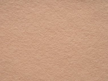 Yakından, yüksek çözünürlüklü görüntü bej bir keçeli yüzey sergiliyor. Yumuşak renkler, sakin ve basitlik duygusunu uyandırmak için ham dokusal güzellikle iç içe geçiyor.