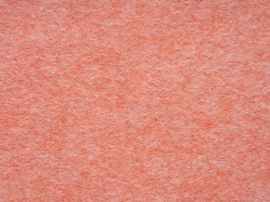 Yakın çekim mercan renkli keçeli yüzey liflerini ortaya çıkarır, sıcaklığı, dokunsal yumuşaklığı ve basit bir tasarımın sükunetini gösterir.