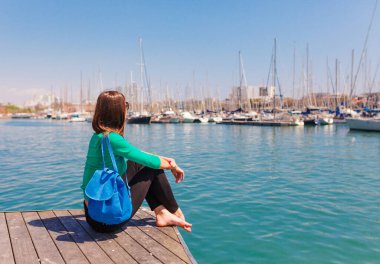 Barselona limanında turist kadın, Katalonya, İspanya. Marina ve yelkenli yatların doğal deniz manzarası. La Ramblaa sokak yakınındaki kamu gezinti ve ünlü turistik yer