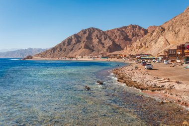 Yaz sıcağında Dahab, Sina, Mısır ve Asya 'da Kızıldeniz kıyılarındaki güneşli tatil köyü plajı. Meşhur turizm merkezi Sharm el Sheikh yakınlarındaki Blue Hole. Parlak güneşli ışık