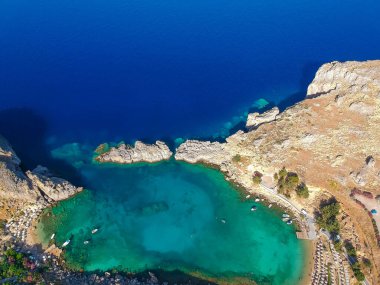 Hava kuşları göz görünümü drone fotoğraf Saint Paul koyun köy Lindos yakın, Rodos adası, Oniki, Yunanistan. Lagün ve berrak mavi su ile güneşli panorama. Güney Avrupa'nın ünlü turistik beldesi