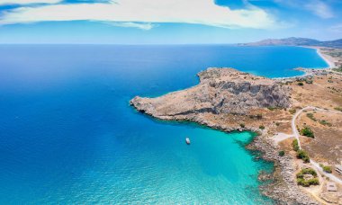 Hava kuşları, Yunanistan 'ın Dodecanese kentindeki Rodos adasındaki Agia Agathi plajı yakınlarında Feraklos kalesinin insansız hava aracı fotoğrafına bakıyor. Kumlu panorama ve berrak mavi su. Güney Avrupa 'nın ünlü turizm beldesi