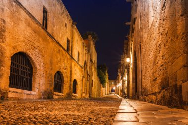 Rodos adasında Rodos şehrinde Şövalyeler antik sokak Gece fotoğrafı, Oniki, Yunanistan. Taş duvarlar ve parlak gece ışıkları. Güney Avrupa'nın ünlü turistik beldesi