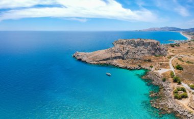 Hava kuşları, Yunanistan 'ın Dodecanese kentindeki Rodos adasındaki Agia Agathi plajı yakınlarında Feraklos kalesinin insansız hava aracı fotoğrafına bakıyor. Kumlu panorama ve berrak mavi su. Güney Avrupa 'nın ünlü turizm beldesi