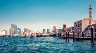 Geleneksel tekneler ve iskeleler ile Dubai Creek silüeti görünümü. Güneşli bir yaz günü. Bae ünlü turistik yer.