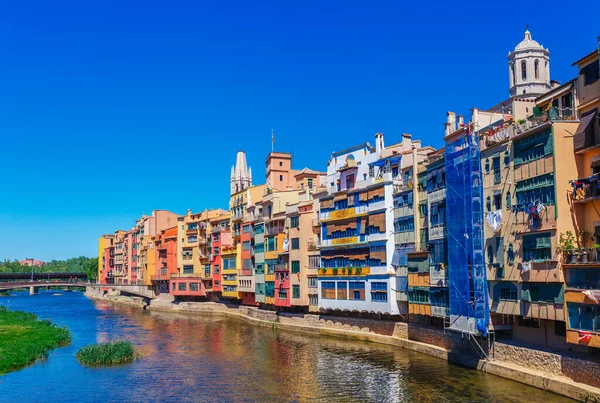 カラフルな赤 オレンジ 黄色の家とジローナ カタルーニャ スペインのオニヤール川を通って橋 風光明媚な古代の町 有名な観光地の目的地は 休日や休暇のための完璧な場所 — ストック写真