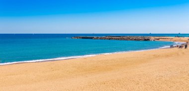 Barselona'daki Barceloneta plajı. Avuç içi güzel kum plaj. Mavi gökyüzü ile güneşli parlak bir gün. Katalonya, İspanya'nın ünlü turistik merkezi
