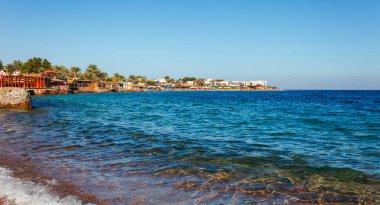 Yaz sıcağında Dahab, Sina, Mısır ve Asya 'da Kızıldeniz kıyılarındaki güneşli tatil köyü plajı. Sharm el Sheikh yakınlarında ünlü bir turizm merkezi. Parlak güneşli ışık