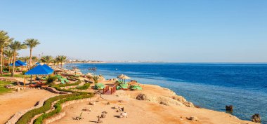 Yaz sıcağında Sharm el Sheikh, Sina, Mısır ve Asya 'da Kızıl Deniz kıyısında palmiye ağaçları olan güneşli bir tatil köyü. Ağız resifi ve kristal berrak su. Ünlü turist mekanı dalış ve şnorkelle yüzme