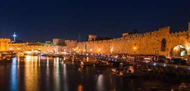 Rodos adasında Rodos kentinde antik kale ve iskele Gece fotoğrafı, Oniki, Yunanistan. Taş duvarlar ve parlak gece ışıkları. Güney Avrupa'nın ünlü turistik beldesi