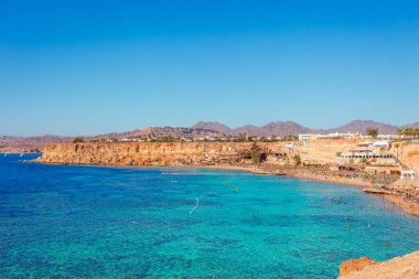 Yaz sıcağında Sharm el Sheikh, Sina, Mısır ve Asya 'da Kızıl Deniz kıyısında palmiye ağaçları olan güneşli bir tatil köyü. Ağız resifi ve kristal berrak su. Ünlü turist mekanı dalış ve şnorkelle yüzme