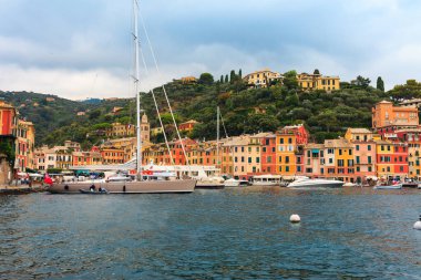 Portofino, Liguria, İtalya 'da deniz manzarası. Geleneksel evleri ve berrak mavi suları olan manzaralı bir balıkçı köyü. Resimli liman ve ünlü ziyaretçilerle dolu yaz tatili zengin tatil beldesi